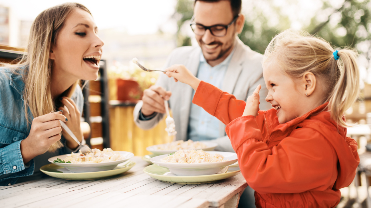 Happy family is enjoying pasta in restaurant.