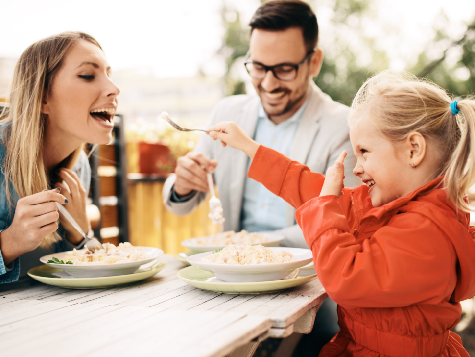Happy family is enjoying pasta in restaurant.