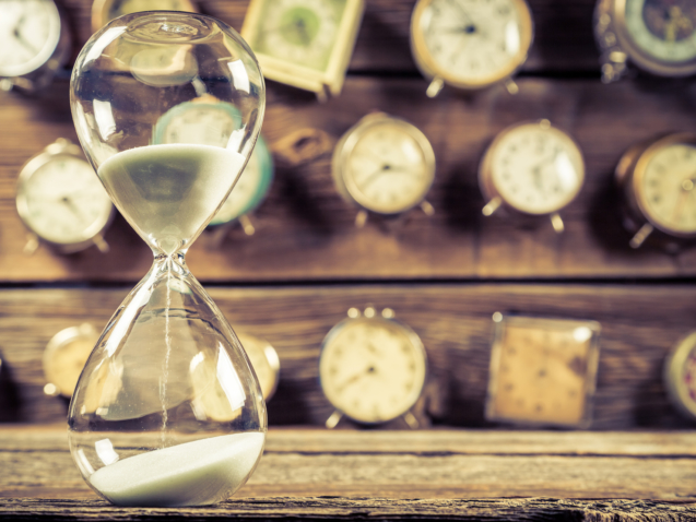 Vintage hourglass on background made of clocks